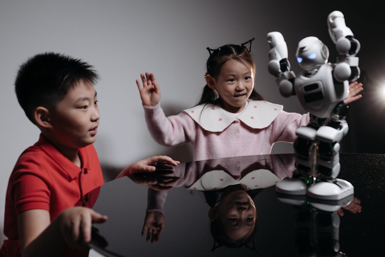 Two kids interacting playfully with a futuristic toy robot indoors.